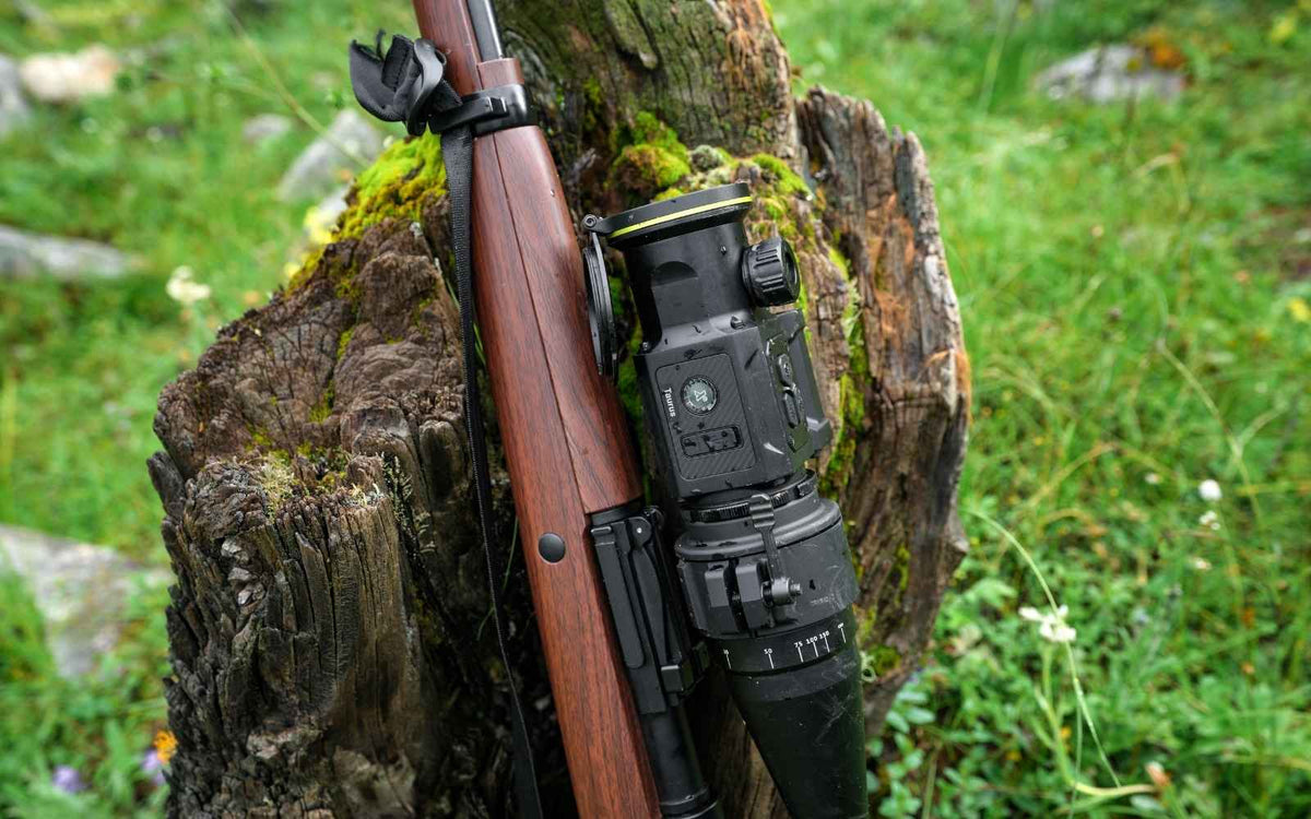 Clip-on thermique Pixfra Taurus avec télémètre laser, fixé sur la lunette d'une carabine en bois et mouillé par la pluie